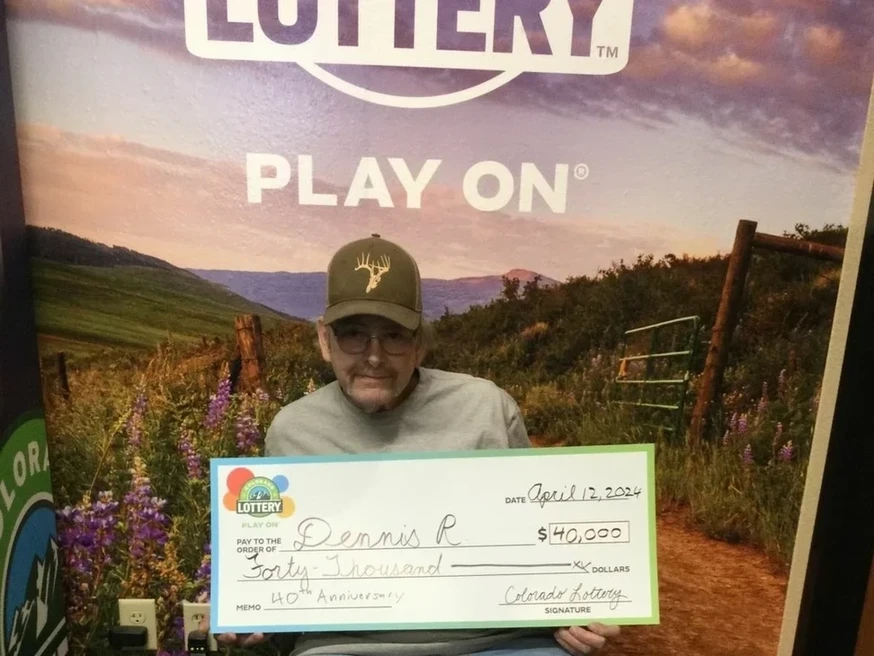 Dennis R. 手持一张 $40,000的超大支票，背景为科罗拉多州彩票
