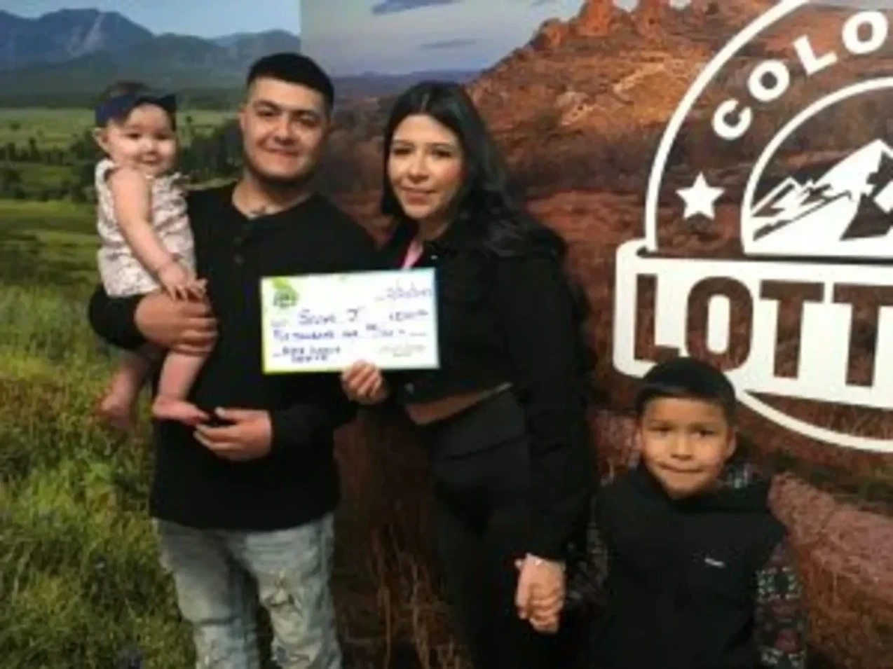 Selyna J. 手持一张价值 20,000 美元的巨型支票，背景为 ColoradoLottery