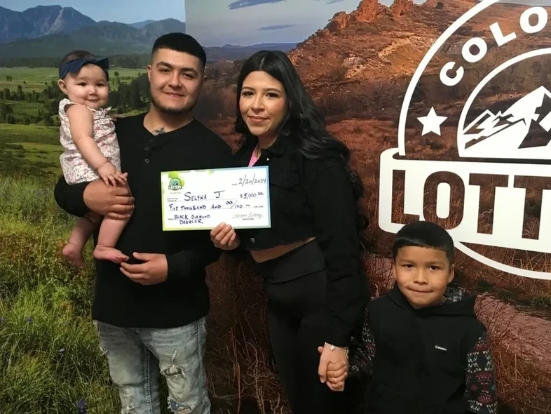 Selyna J. 手持一张价值 20,000 美元的巨型支票，背景为 ColoradoLottery